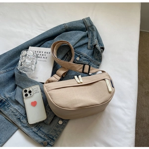 Minimalist beige dumpling bag shown with a denim jacket and lifestyle accessories