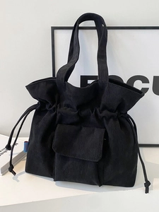 Bolso tote minimalista de pana negra con cierre de cordón y bolsillo frontal