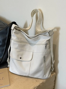Grande borsa tote bianca minimalista con tasche funzionali su superficie in pietra