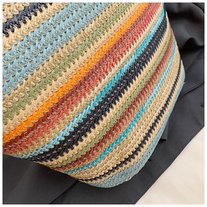 Macro detail of multi-color striped woven texture on summer straw tote handbag