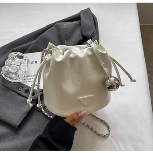 Detail of white leather drawstring bucket bag with silver chain and sphere charm