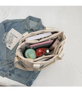 Interior view of off-white quilted tote bag showing large capacity with daily essentials