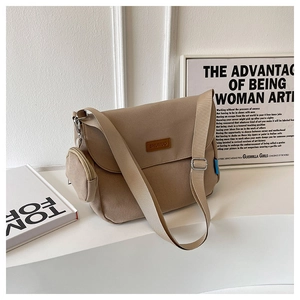 Close-up of khaki canvas messenger bag with adjustable strap and small round pouch