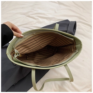 Close-up of mint green tote bag with striped lining and high-quality zipper detail
