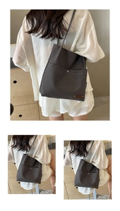 Detail of dark grey canvas tote bag with metal buckle and shoulder strap