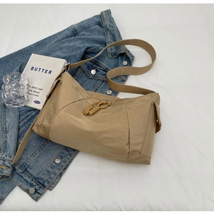 Dettaglio borsa a tracolla in nylon marrone chiaro con tiranti zip intrecciati e tracolla