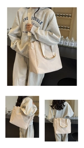 Detailed macro view of nylon tote bag featuring wide fabric straps and golden hardware