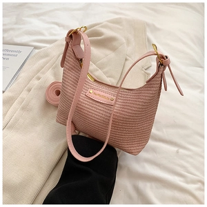 Détail du sac bandoulière tressé rose avec finitions dorées et sangle amovible