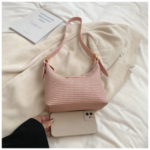 Comparaison de taille d'un sac demi-lune rose tressé avec un smartphone