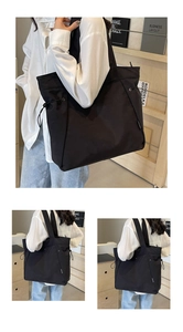 Detail of black nylon tote bag featuring unique side drawstring and wide straps