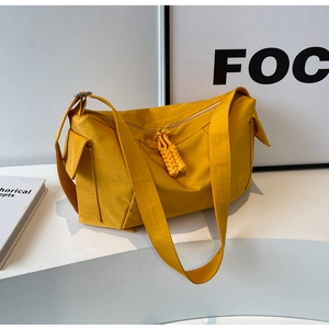 Dettaglio della borsa a tracolla in tela gialla con tiranti della cerniera in corda intrecciata