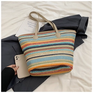 Top view of colorful striped woven straw tote bag with beige faux leather straps