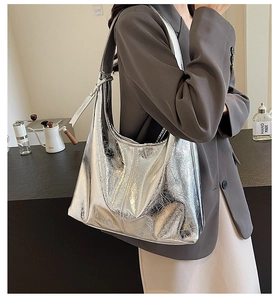 Macro shot of silver hobo bag with metallic pleated texture and wide shoulder strap