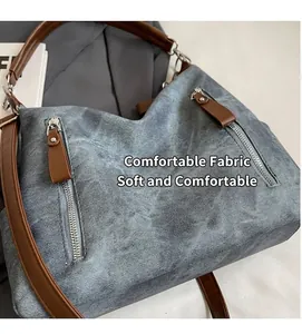 Detailansicht der blauen Canvas-Tasche mit braunen Ledergriffen und silbernen Reißverschlüssen