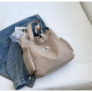 Macro detail of khaki canvas tote bag with fashion tag and side zipper pocket
