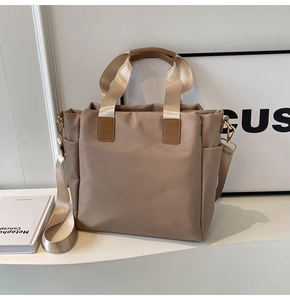 Detail view of khaki nylon tote bag with wide strap and convenient side pocket