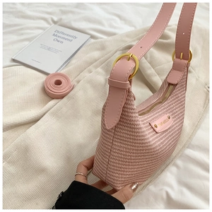 Gros plan du sac hobo rose tissé montrant la texture, les ferrures dorées et lanières