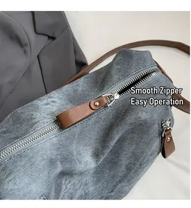 Nahaufnahme eines glatten Metallreißverschlusses an einer blauen Denim-Tasche mit Leder