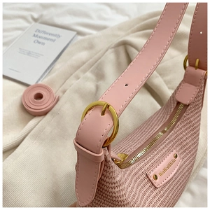 Détail du sac hobo tissé rose clair avec boucle en métal doré et fermeture éclair