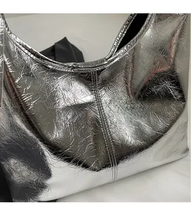 Detailed close-up of metallic silver bag showing soft pleated texture and stitching