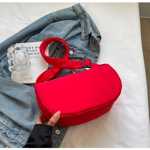 Close-up of bright red minimalist nylon crescent bag with adjustable wide shoulder strap