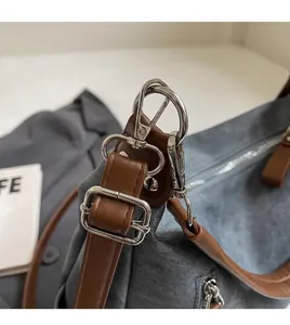 Detail des verstellbaren Lederriemens und der silbernen Hardware an der Denim-Tasche