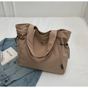 Top view of a large khaki nylon tote bag with side drawstrings and magnetic closure