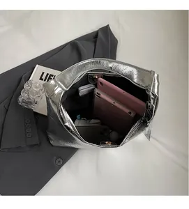 Detailed interior view of silver tote bag showing large capacity with tablet and phone