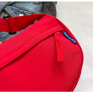 Detail of red nylon crossbody bag with Kefeier label and black adjustable buckle