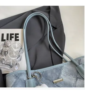 Macro shot of light blue denim texture tote bag with vintage quilted pattern and metal logo