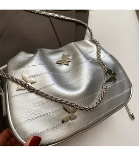 Détail du sac seau en cuir plissé argenté avec papillons métalliques et bandoulière