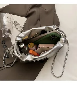 Vue de dessus du sac seau argenté métallisé montrant l'espace intérieur avec maquillage