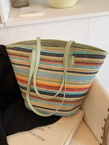 Colorful striped woven straw tote bag with long green handles and top zipper closure
