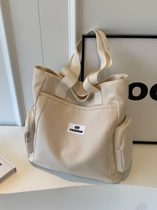 Minimalist beige canvas tote bag with large capacity for commuting shown on white background