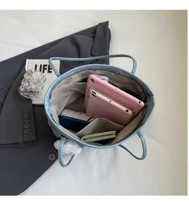 Interior view of light blue tote bag showing large storage space and pocket layout
