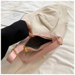 Détails du sac bandoulière tissé rose avec fermeture éclair dorée et sangle réglable