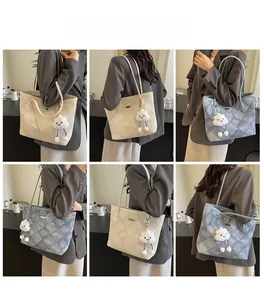 Detail view of large tote bag with quilted diamond pattern and cute plush cloud charm