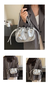 Détail du sac seau argenté avec cordon de serrage, papillons et bandoulière chaîne