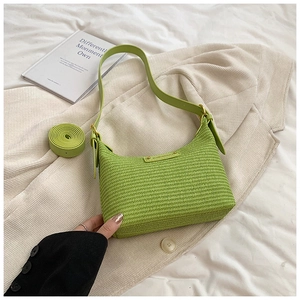 Détail du sac bandoulière en paille vert clair avec plaque dorée et sangle