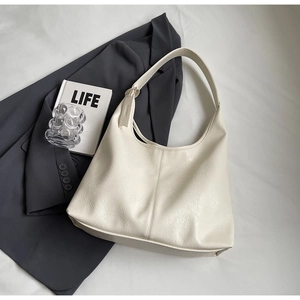 Detail of off-white hobo bag with unique pleated texture and wide integrated strap