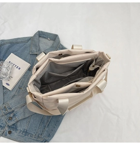 Interior view of quilted cream tote bag showing three compartments and magnetic closure