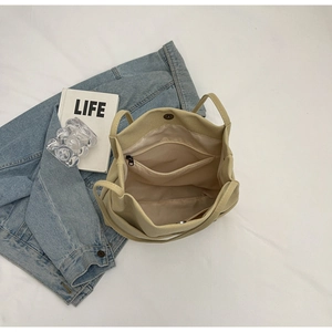 Interior view of canvas tote bag showing large compartment and zip pocket with magnetic closure