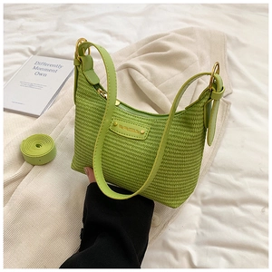 Détail d'un sac hobo tissé vert avec garnitures dorées et bandoulière amovible incluse