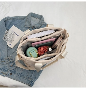Detailed interior of quilted tote bag showing storage for tablet, books and water bottle