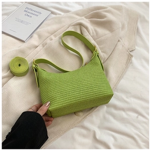 Vue détaillée de la texture de paille tressée vert citron et de la bandoulière en cuir