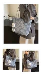 Close-up of light blue quilted denim tote bag with soft white plush cloud charm detail