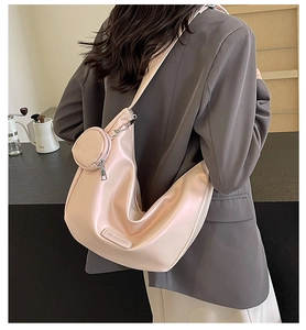 Lifestyle shot of a stylish silver metallic half-moon bag with a small coin purse charm