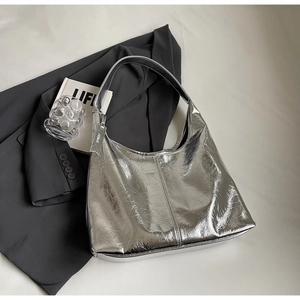 Detail of silver metallic hobo bag with pleated texture on a grey blazer suit