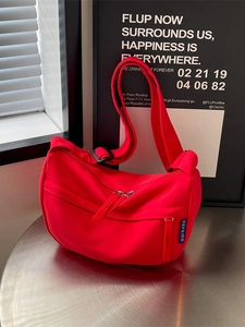 Minimalist red nylon crossbody dumpling bag with wide adjustable black shoulder strap