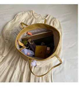 Vue de dessus du grand sac cabas en paille avec tablette, portefeuille et accessoires